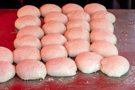 Raw wheat dough on metal table ready for making buns