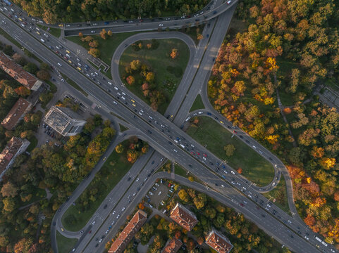 Aerial view of a highway interchange surrounded by vibrant autumn trees and urban buildings in Sofia, Sofia City Province, Bulgaria.