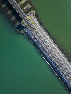 Aerial view of the railway tracks crossing the water on a stone embankment in Malahide, County Dublin, Ireland.