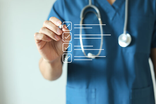 close up young general practitioner hand use stylus pen to check box on medical checklist or opd record to read and diagnose and assess about patient's symptom for healthy and lifestyle concept