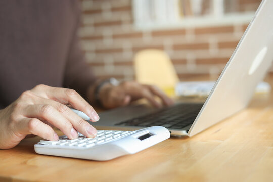 close up man hand press on calculator and check invoice letter from bank to check about debt and spending monthly for people lifestyle and inflation economic concept
