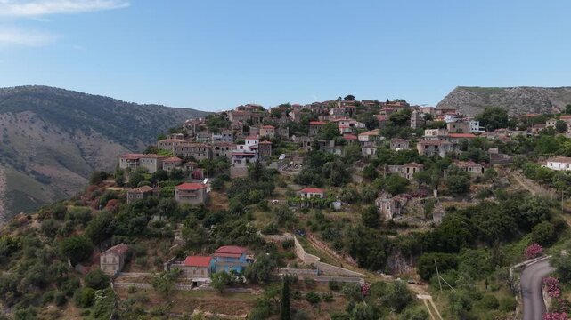 Aerial view of the historic stone houses and lush greenery of the hillside village of Qeparo, Vlore County, Albania.