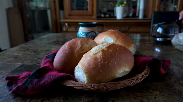 Hand taking mexican bolillo bread from basket during a traditional breakfast