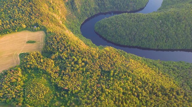 Aerial view of the Solenicka podkova, a dramatic horseshoe-shaped meander of the Vltava River surrounded by dense forests and agricultural fields in Zduchovice, Central Bohemian Region, Czechia.