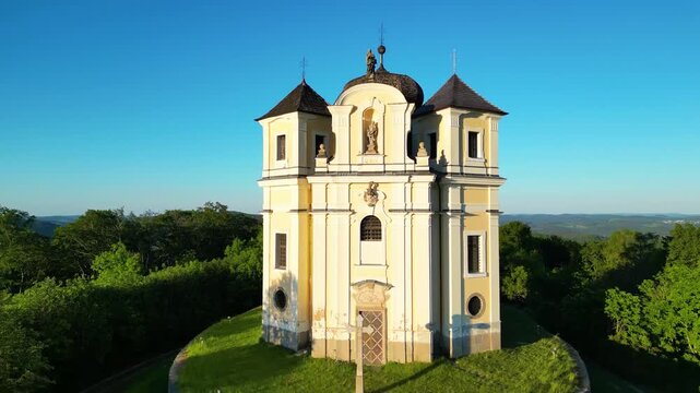 Aerial view of the historic Makova hora church surrounded by lush greenery and trees in Smolotely, Stredocesky kraj, Czechia.