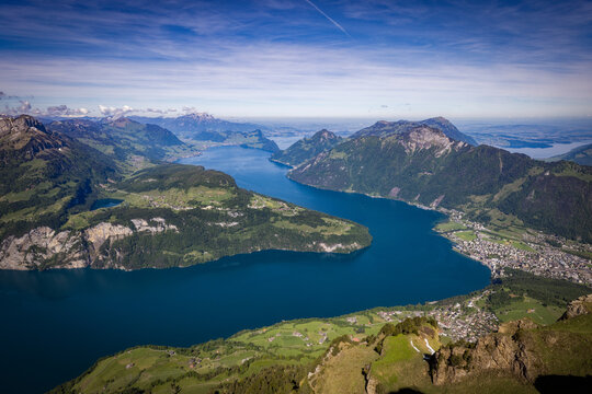 View of the Stoos mountain region overlooking the deep blue waters of Lake Lucerne surrounded by lush green alpine slopes and mountain peaks in Schwyz, Schwyz, Switzerland.