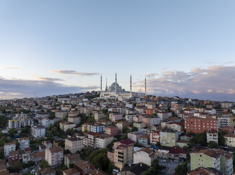 Aerial view of the Grand Camlica Mosque rising above the dense urban landscape of residential buildings and rooftops in Uskudar, Istanbul, Turkiye.