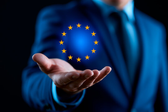 Businessman holding glowing digital European Union flag hologram over extended hand