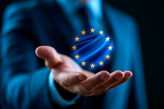 Businessman holding glowing digital European Union flag hologram over extended hand