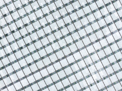 Aerial view of a large greenhouse roof with a grid pattern used for food production in Poland.