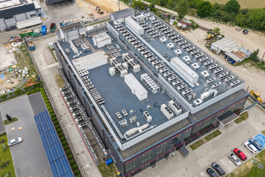 Aerial view of hyper scale data center with numerous cooling units on the roof and solar panels in the parking area in Warszawa, Wojewodztwo mazowieckie, Poland.