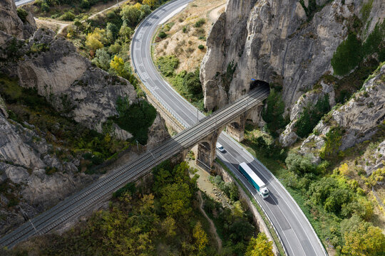 Aerial view of the historic Viaducto de Las Termopilas spanning a deep rocky gorge with a railway line passing through a tunnel and a highway below in Pancorbo, Castilla y Leon, Spain.
