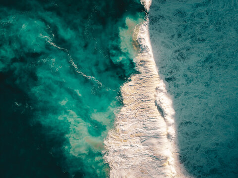 Aerial view of Sandpatch coastline with turquoise ocean waves crashing and white sea foam in Sandpatch, Western Australia, Australia.
