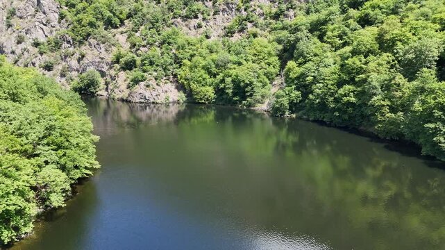 Drone Shot of Vltava River, Green Trees and Rocky Cliff in Czech Republic. Summer Landscape with Water Reflection in Central Bohemia.