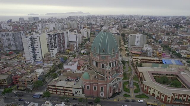 Aerial view of the Iglesia Inmaculado Corazon de Maria surrounded by urban buildings and streets in Magdalena del Mar, Lima Province, Peru.