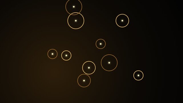 Glowing golden circles of various sizes with bright central points float and gently drift across a dark, warm-toned background, creating an elegant and mesmerizing abstract visual effect