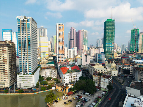 Aerial view of the dense urban skyline of Manila featuring modern high-rise buildings, construction sites, and the Pasig River in Manila, Metro Manila, Philippines.