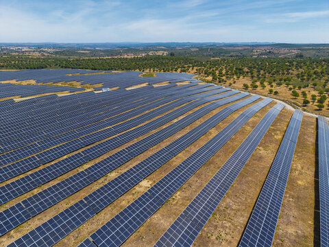Aerial view of a large solar farm with rows of photovoltaic panels installed in a rural landscape near Gioes, Faro, Portugal.