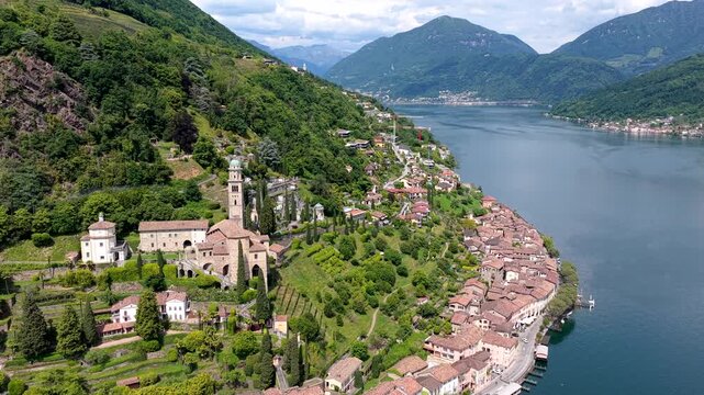 Aerial view of the historic village of Morcote with its iconic church and terraced gardens situated along the shore of Lake Lugano, Lugano, Ticino, Switzerland.