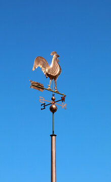 Copper rooster weather vane against a clear blue sky