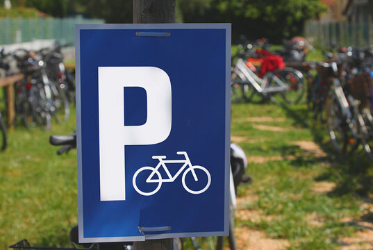 Blue bicycle parking sign with white letter P and bike symbol outdoors