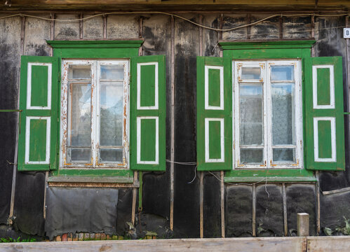 Vilnius, Lithuania - 09 July 2026: View of traditional wooden house windows with weathered green shutters in the historic Snipiskes district.
