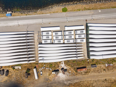 Aerial view of wind turbine blades stored in a logistics yard near the coast in Sines, Setubal, Portugal.