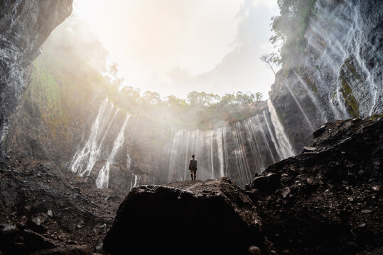 Scenic View of a Majestic Waterfall Flowing in a Lush Green Forest at Sunrise