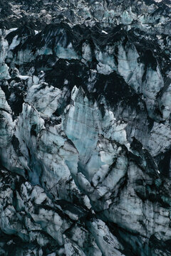 Aerial view of the rugged ice formations and dark volcanic ash layers of the Myrdalsjokull glacier in Vik, Myrdalshreppur, Iceland.