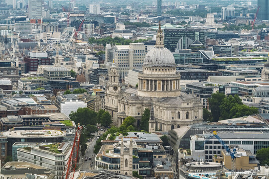 Aerial view of St. Paul's Cathedral surrounded by historic and modern urban architecture, rooftops, and city streets in London, England, United Kingdom.