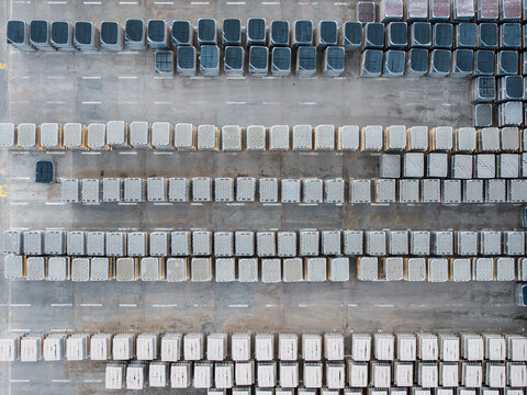 Aerial view of organized rows of stacked concrete paving stones and blocks in various shades and textures at a manufacturing facility in Riga, Latvia.