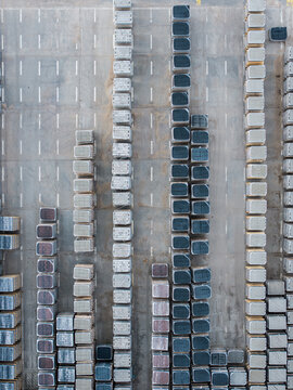 Aerial view of stacked concrete paving stones and construction materials arranged in rows at a manufacturing facility in Riga, Latvia.