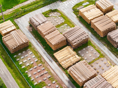 Aerial view of stacked lumber piles in an industrial storage yard in Latvia.