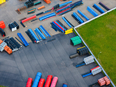Aerial view of a polymer pipe manufacturing facility with rows of colorful plastic piping systems and conduit pipes stored in an industrial yard in Jelgava, Latvia.