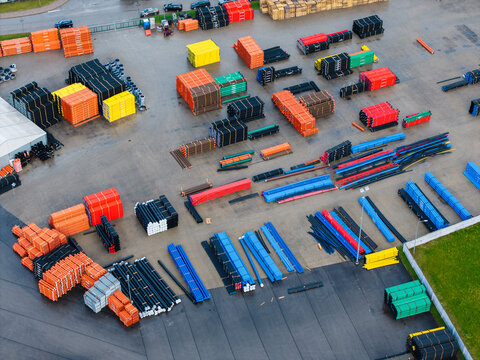 Aerial view of a polymer pipe manufacturing facility with organized stacks of colorful plastic piping systems for infrastructure and construction projects in Jelgava, Latvia.