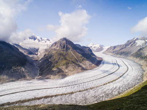 Aerial view of the Aletsch Glacier from the Eggishorn viewpoint, showcasing the massive ice river winding through the rugged mountain peaks in Fiesch, Wallis, Switzerland.