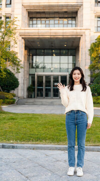 Asian Student Waving in Front of Academic Building