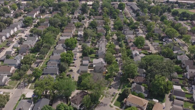 Columbus, Ohio neighborhood from drone aerial above homes, houses, streets, alleyways, intersections, cars, and people during a warm summer day with greenery green trees and sunny weather in midwest