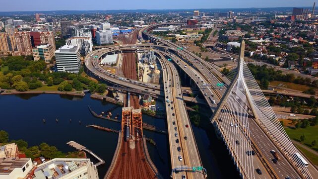 Flight near the Leonard P. Zakim Bunker Hill Memorial Bridge in Boston, Massachusetts, USA. Multiple cars go by the roads and bridges across the Charles River.