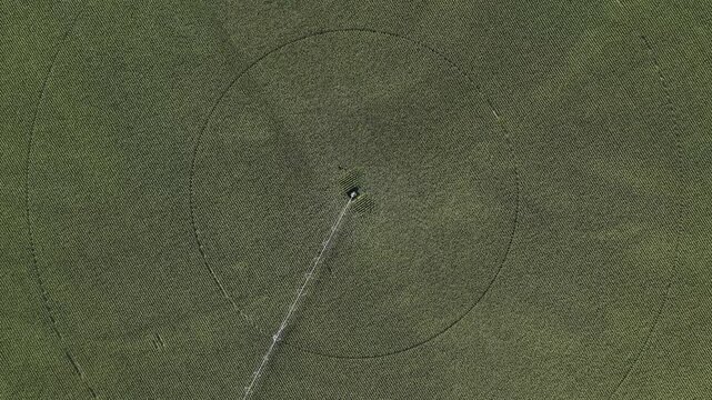 Aerial view of a circular crop field with a center pivot irrigation system in Hombourg, Grand Est, France.
