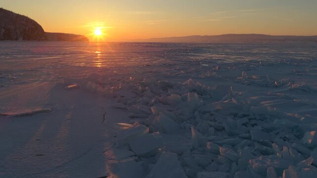 Aerial view of Lake Baikal at sunset with ice chunks on the frozen surface in Khuzhir, Irkutsk Oblast, Russia.