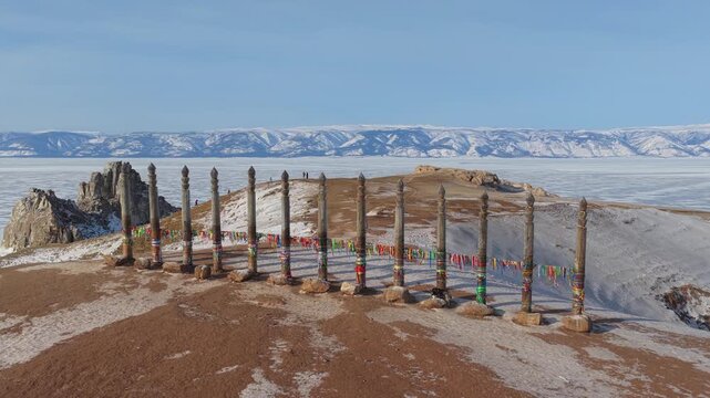 Aerial view of the ritual wooden pillars at Burkhan Cape on Olkhon Island overlooking the frozen expanse of Lake Baikal in Khuzhir, Irkutsk Oblast, Russia.