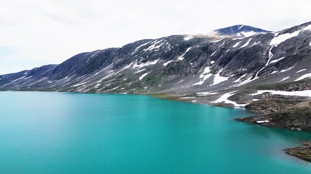 Aerial view of the turquoise glacial lake along the Old Strynefjell Mountain Road in Stryn Municipality, Vestland, Norway.