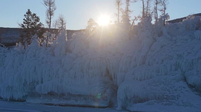 Aerial view of Lake Baikal with frozen trees and ice formations under a bright sun in Khuzhir, Irkutsk Oblast, Russia.
