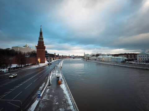Moscow, Russia - 14 December 2025: View of the Moscow Kremlin tower and walls along the Moskva River on a winter day with snow on the ground and a cloudy sky.