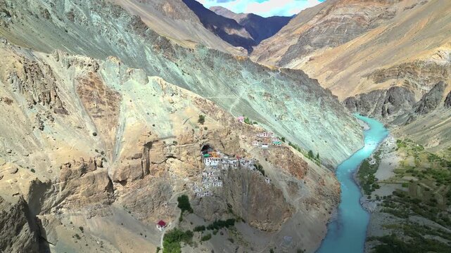 Aerial view of Phukthal Gompa monastery built into a cliffside overlooking the Tsarap River in Phugtal, Himachal Pradesh, India.