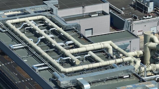 Close aerial view of industrial rooftop ventilation, air handling and large duct systems at a modern high-tech manufacturing facility