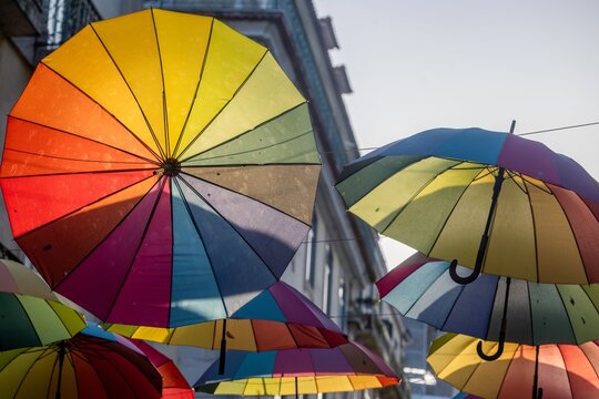 Lisboa, Portugal - 09 July 2026: View of the iconic colorful umbrellas suspended above Pink Street, creating a vibrant canopy against the historic buildings of the city.