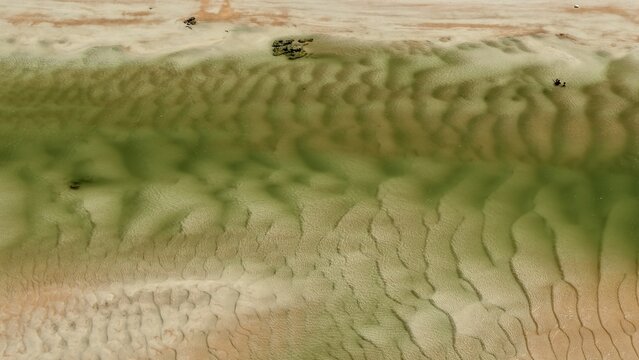 Aerial view of the sandbars and shallow tidal waters at Matanzas Inlet, showcasing intricate ripple patterns in the sand in St. Johns County, Florida, United States.