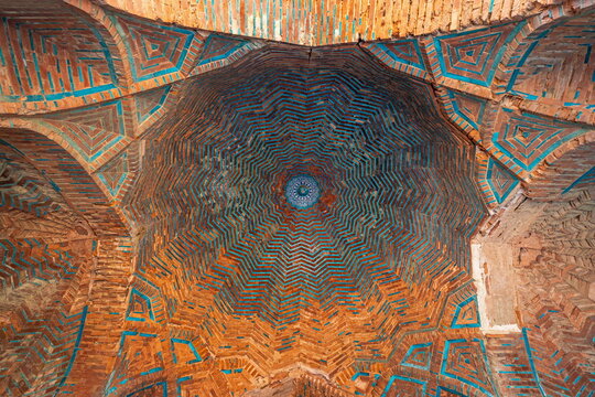 View of the intricate brickwork and blue tile patterns on the interior ceiling of a historic dome at the Makli Necropolis in Thatta, Sindh, Pakistan.